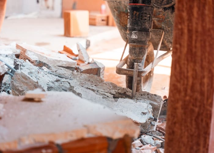 Een sloophamer breekt een betonnen vloerplaat open