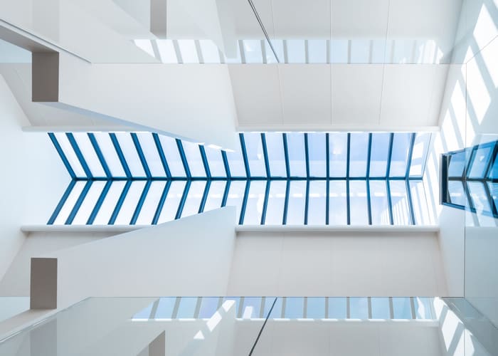 De afgewerkte traphal in het wit, met de lichtstraat erboven