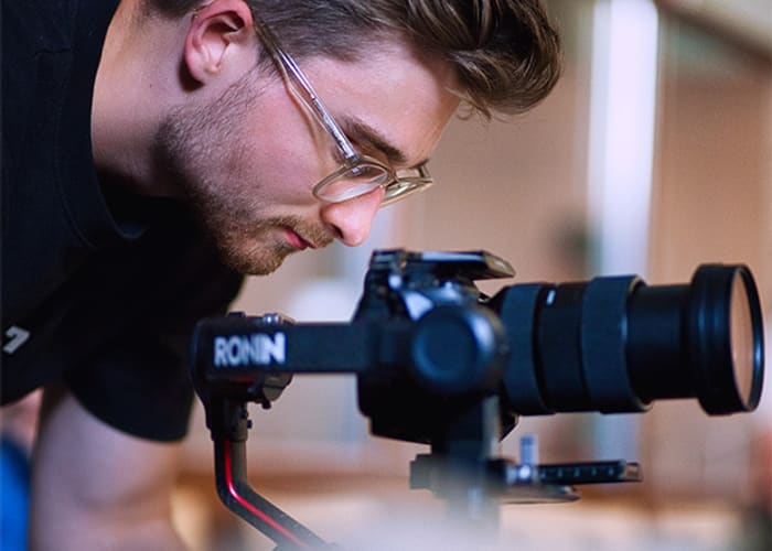 Cameraman kijkt gebogen naar het scherm van zijn camera op een gimbal