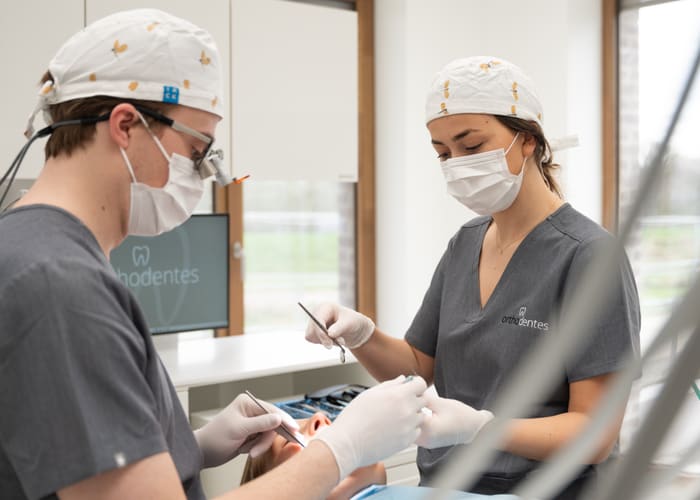 Twee behandelaars met instrumenten aan de behandelstoel