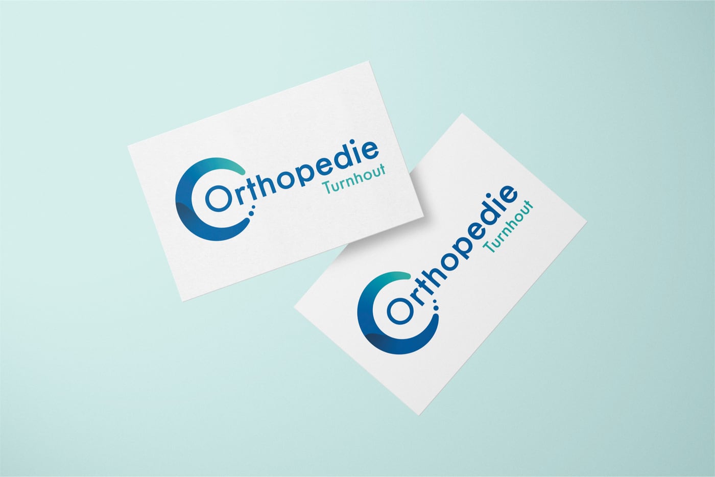 Twee visitekaartjes van Orthopedie Turnhout op een zeegroene ondergrond