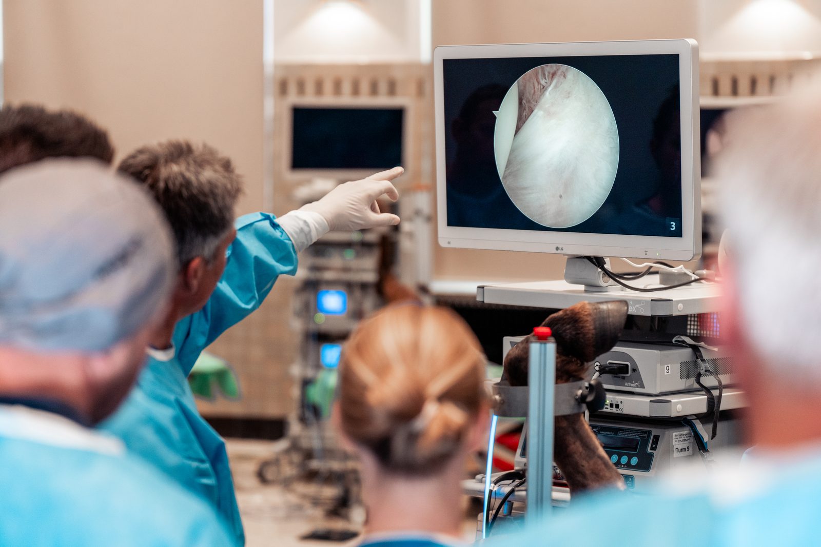 Zorgverleners kijken naar een endoscopisch beeld op een scherm in de operatiezaal