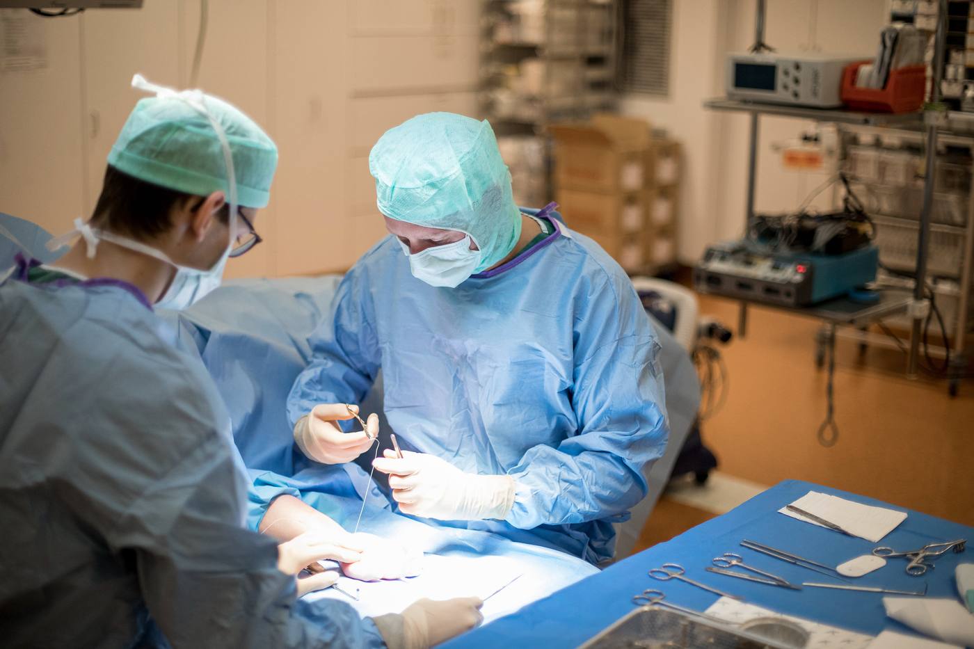 Twee chirurgen in steriele kledij tijdens een ingreep in het operatiekwartier
