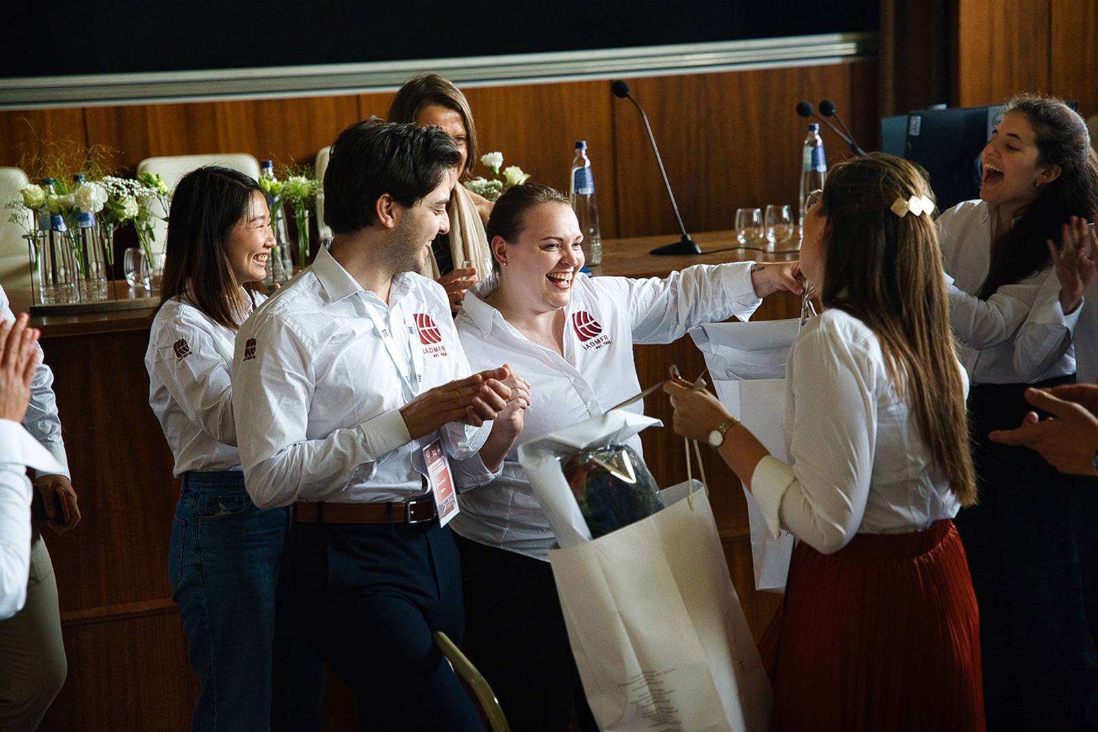 Enthousiast congresteam in bedrijfshemden dat elkaar feliciteert